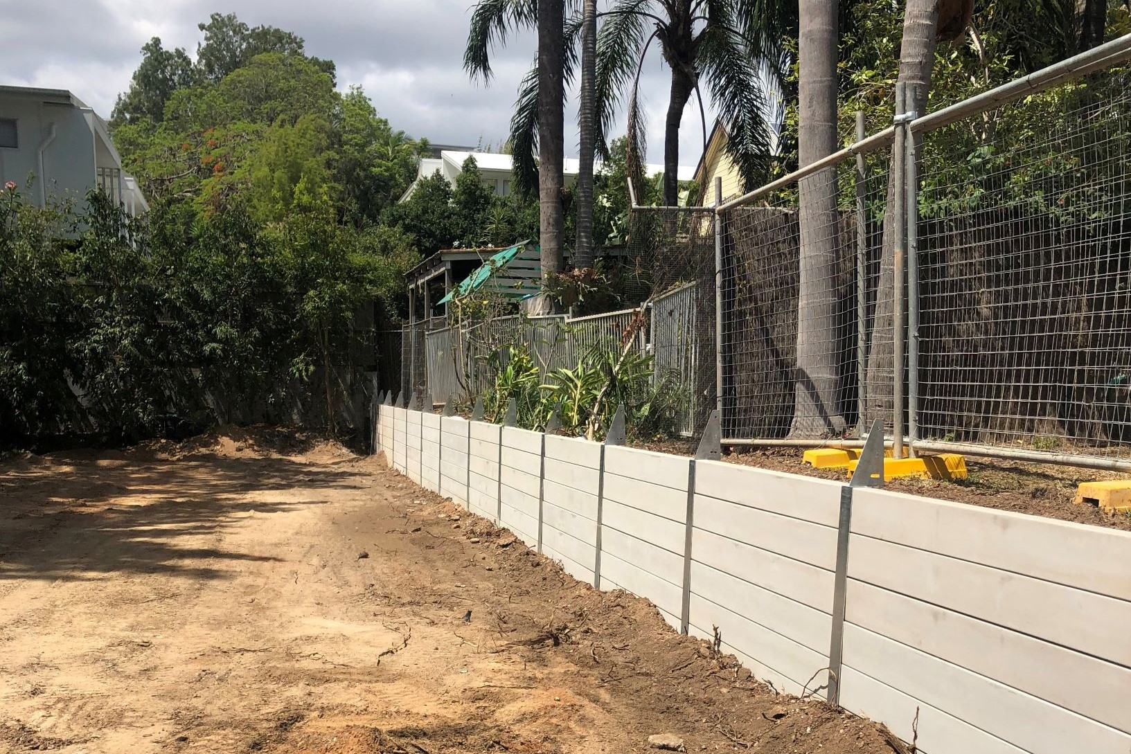 Durawall retaining wall on boundary inner Brisbane with fence brackets attached